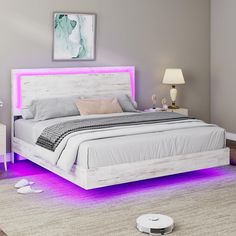 a white bed with purple lights on the headboard and foot board in a bedroom