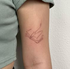 a woman's arm with a tattoo on it that has a book in it