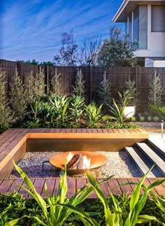 an outdoor garden with wooden steps and plants in the center, surrounded by greenery