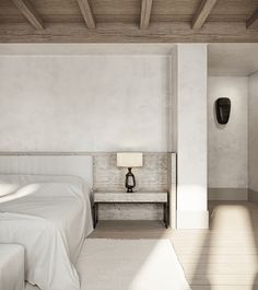 an empty bedroom with two beds and a lamp on the side of the bed in front of it