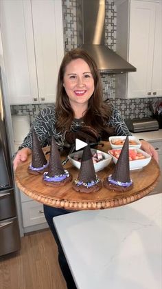 a woman holding a tray with cones on it