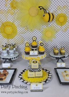 a table topped with cupcakes and cakes covered in yellow frosting