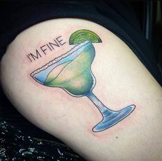 a woman's thigh with a margarita tattoo on it