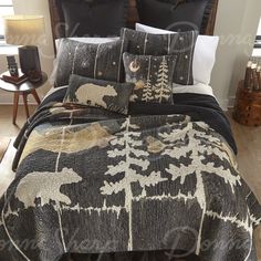 a bed covered in black and white comforter next to a night stand with two lamps