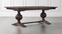 a wooden table sitting on top of a hard wood floor next to a white wall