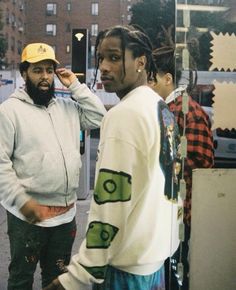 two men standing next to each other on the street