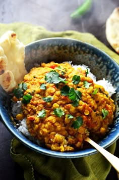 a bowl filled with rice and vegetables next to pita bread on top of a table