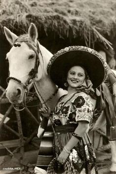 a woman standing next to a horse wearing a sombrero