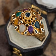 This gorgeous princess ring is accented with nineteen round cut sapphires and eight pear cut colored gemstones including chalcedony, tiger's eye, rock crystal, amethyst, sapphire, topaz, citrine, and ruby all set in to bezel settings. The ring is crafted 14k yellow gold and is currently a size 6.5. Luxury Yellow Gold Gemstones With Accents, Luxury Multi-stone Gemstones For Collectors, Luxury Multi-stone Collectible Gemstones, Luxury Collectible Multi-stone Gemstones, Exquisite Multi-stone Gemstone Ring, Vintage Multi-stone Gemstones For Wedding, Unique Multi-stone Gold Amethyst Ring, Unique Gold Multi-stone Amethyst Ring, Crystal Amethyst