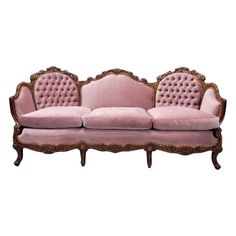 a pink couch sitting on top of a wooden frame