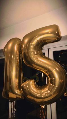 a large golden balloon shaped like the letter s is shown in front of a doorway