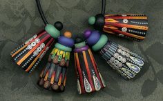 an assortment of colorful necklaces on a black cord with bead work in the middle