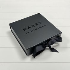 the harry groomsman gift box is open and has a black ribbon around it's corner