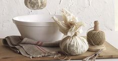 an assortment of kitchen items on a cutting board next to a bowl and spoons