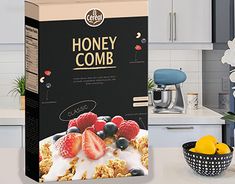 a box of honey comb with berries and blueberries in it on a kitchen counter