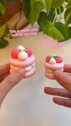 two hand holding small toy doughnuts with toppings on them, one is pink and the other is white