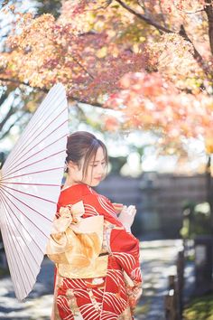 a woman in a kimono holding an umbrella