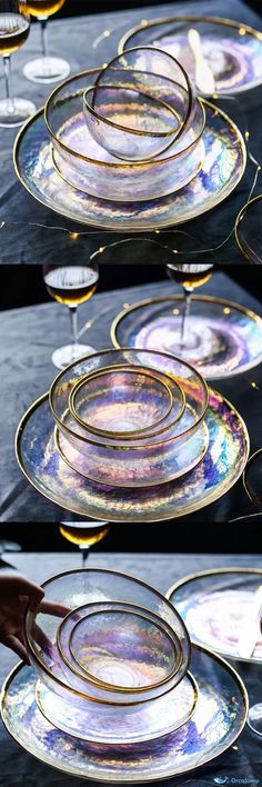 plates with gold rims are stacked on top of each other and being held by someone's hand