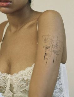 a woman with a tattoo on her arm and chest is looking off to the side