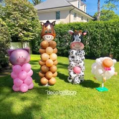 three inflatable animals are standing on the grass with balloons attached to their heads