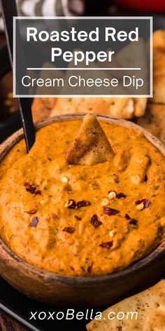 roasted red pepper cream cheese dip in a wooden bowl with crackers on the side