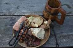 a wooden plate topped with meat and cheese next to a mug filled with hot chocolate