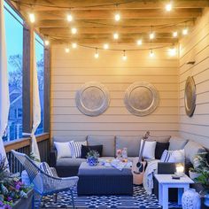 an outdoor living area with patio furniture and string lights