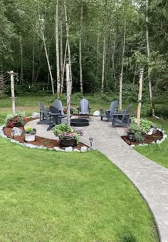 an outdoor patio with chairs and flowers in the center, surrounded by trees on either side