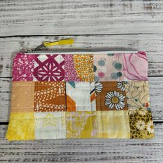 a multicolored patchwork purse sitting on top of a wooden table