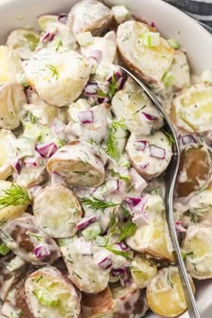 a white bowl filled with potato salad and a spoon