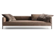 a brown leather couch with two pillows on it's back and the seat up