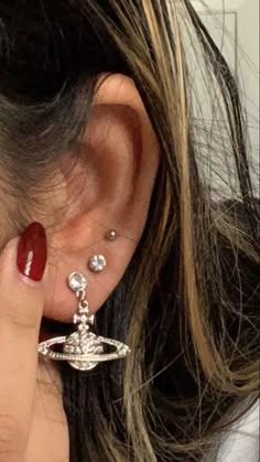 a close up of a person's ear with some piercings on top of it