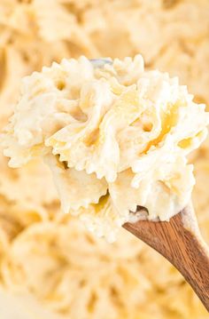 a wooden spoon filled with mashed potatoes and cream