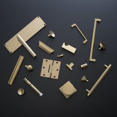 various brass hardware and handles on a black surface