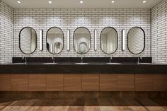 a public restroom with four sinks and mirrors