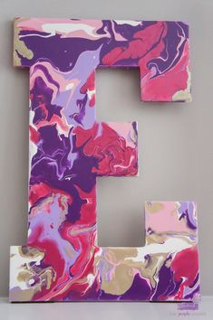 the letter e is made up of marbled paper and painted with pink, purple, yellow and white colors