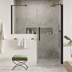 a walk in shower sitting next to a green stool and towel rack on the wall