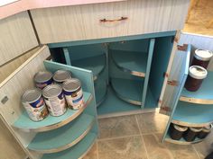 an open cabinet with some paint cans in it