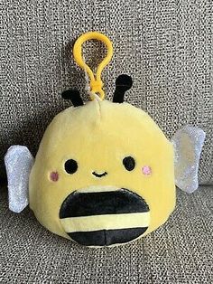 a yellow stuffed animal with angel wings on it's head and eyes, sitting on a couch