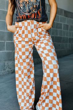 Our mid-rise Checkmate Pants are here to take trousers to another level. With a comfy elastic waistband and a wide-leg fit, they'll have you looking stylish and feeling cozy! Perfect for a casual day out, the washed black and white checkered print creates a bold and stylish look. Go ahead, make your move! Mid-rise waist Comfy elastic waistband Wide leg fit Camel and white checkered print 80% Polyester, 15% Rayon, 5% Spandex See Lily's sizing HERE, she is wearing size Small See Margie's sizing HERE, she is wearing size Large 1st Day Of College, Edgy Boho Outfits, Tennessee University, College Semester, Wide Leg Lounge Pants, Checkered Pants, Casual Sweatpants, Wide Leg Sweatpants, Loose Trousers