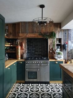 a kitchen with black and white tiles on the floor, green cabinets and an oven