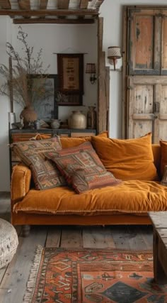 a living room with an orange couch, rugs and wooden doors in the background