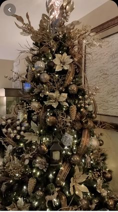 a christmas tree decorated with gold and silver ornaments