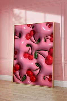 a pink painting with cherries and leaves on it in front of a wooden floor