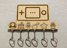 a wooden key holder with keys hanging from it's sides and an image of a nintendo game controller on the front