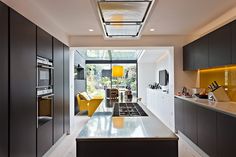 a modern kitchen with yellow accents and black cabinets