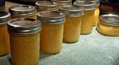 several jars filled with yellow liquid sitting on top of a blue towel next to an oven