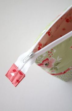 an open zippered pouch sitting on top of a white table next to a wall