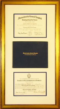 two framed diplomas are on display in a wooden frame with gold trim and black paper