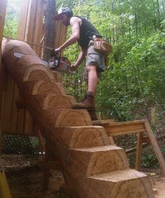 a man with a chainsaw working on a wooden structure in the woods